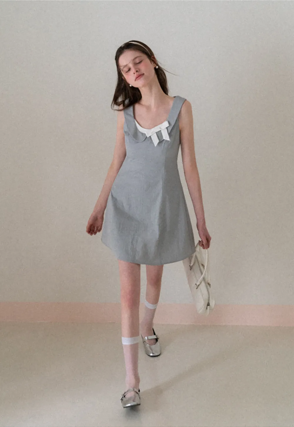 Sleeveless dress with Peter Pan collar and bow detail