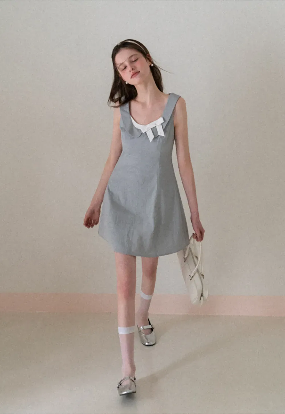 Sleeveless dress with Peter Pan collar and bow detail