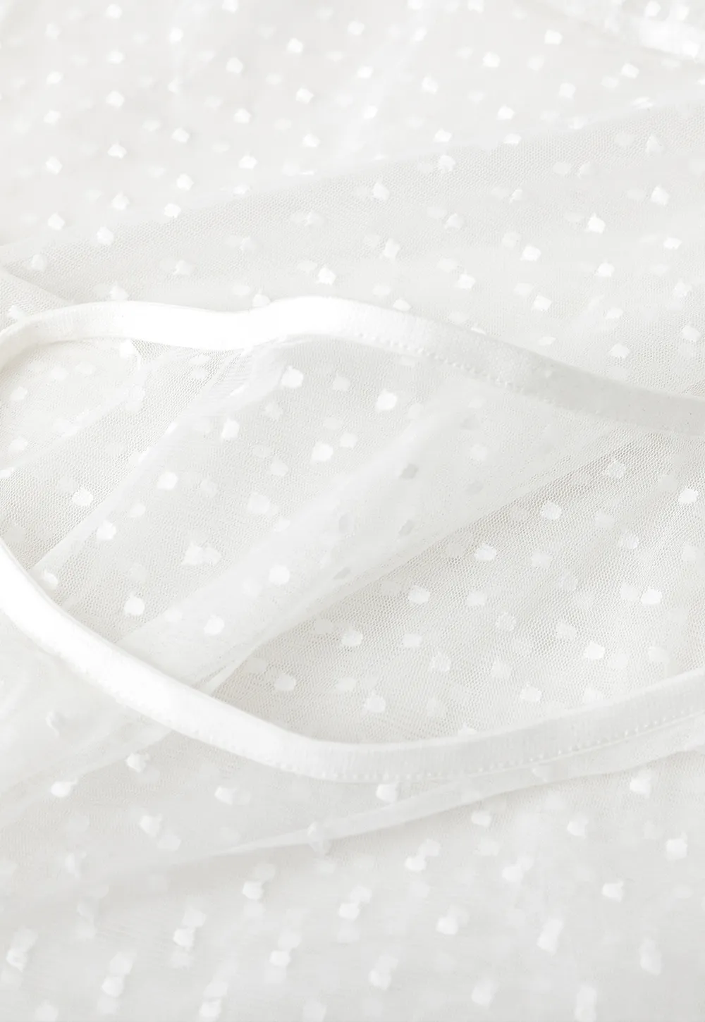 Sheer polka dot top with ruffled hem and puff sleeves