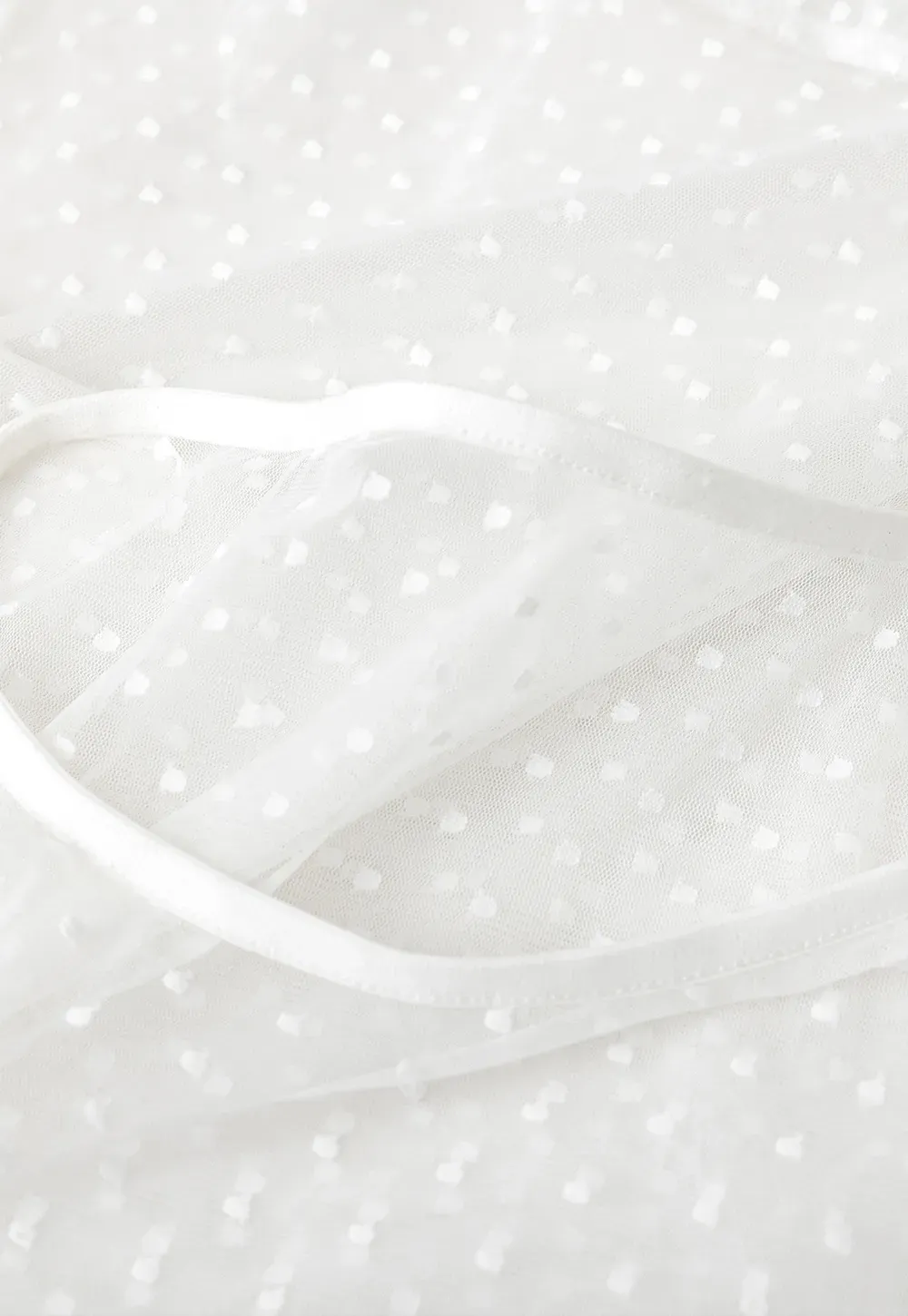 Sheer polka dot top with ruffled hem and puff sleeves