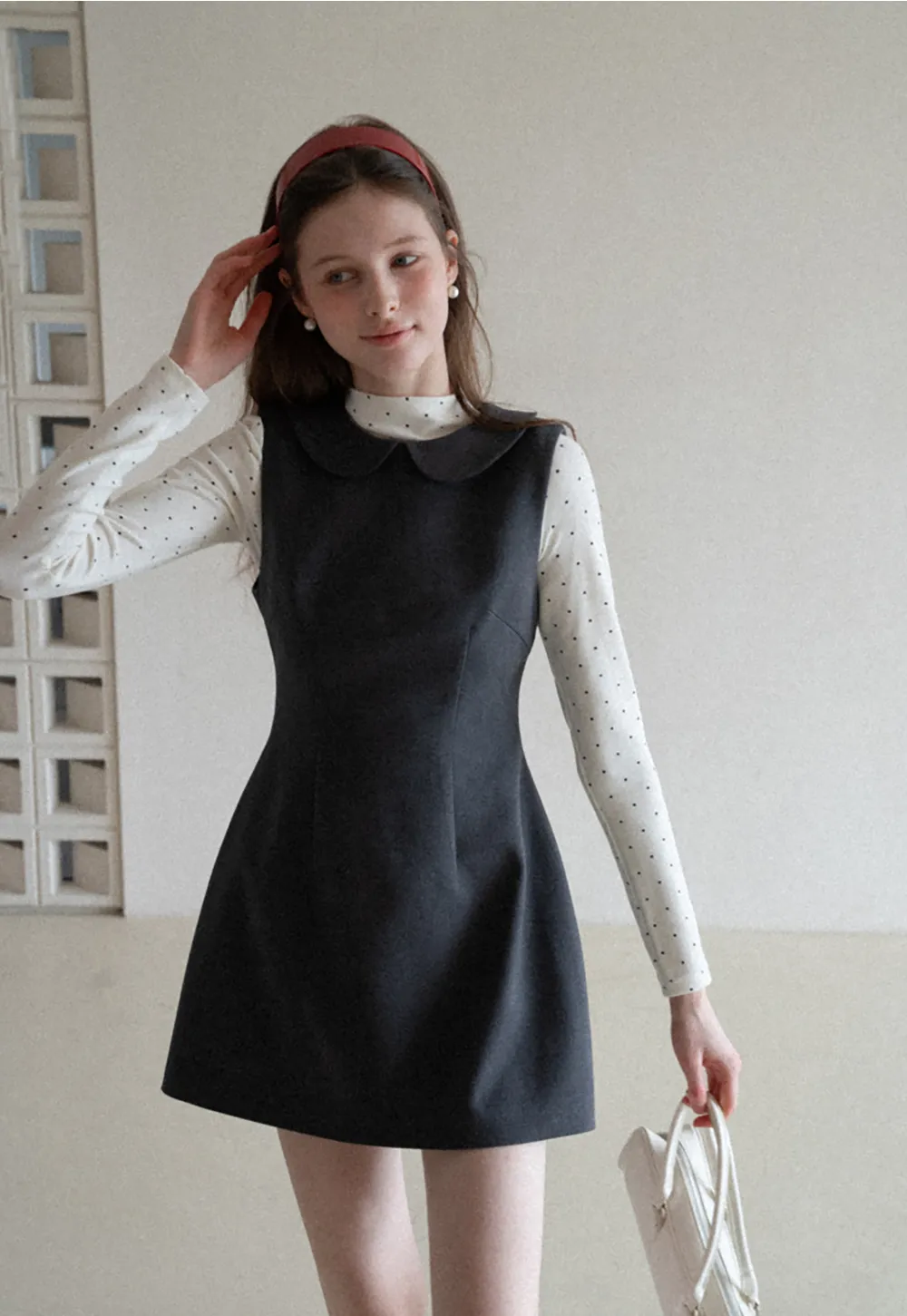 Elegant sleeveless dress with collar layered over polka dot top