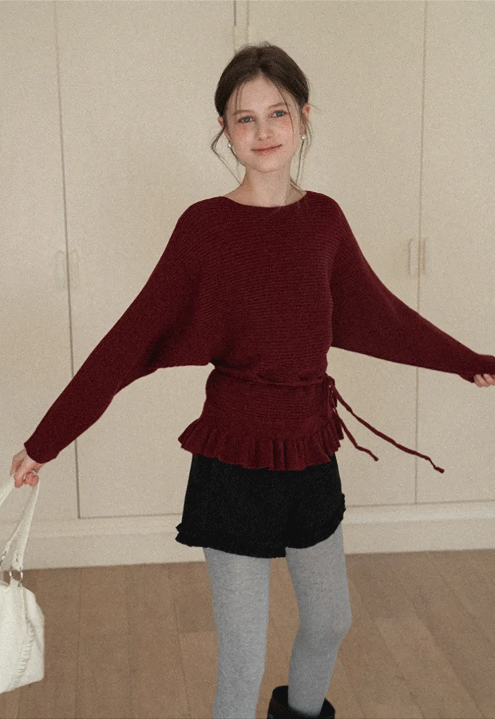 Ribbed knit sweater with tie back and flared hem design