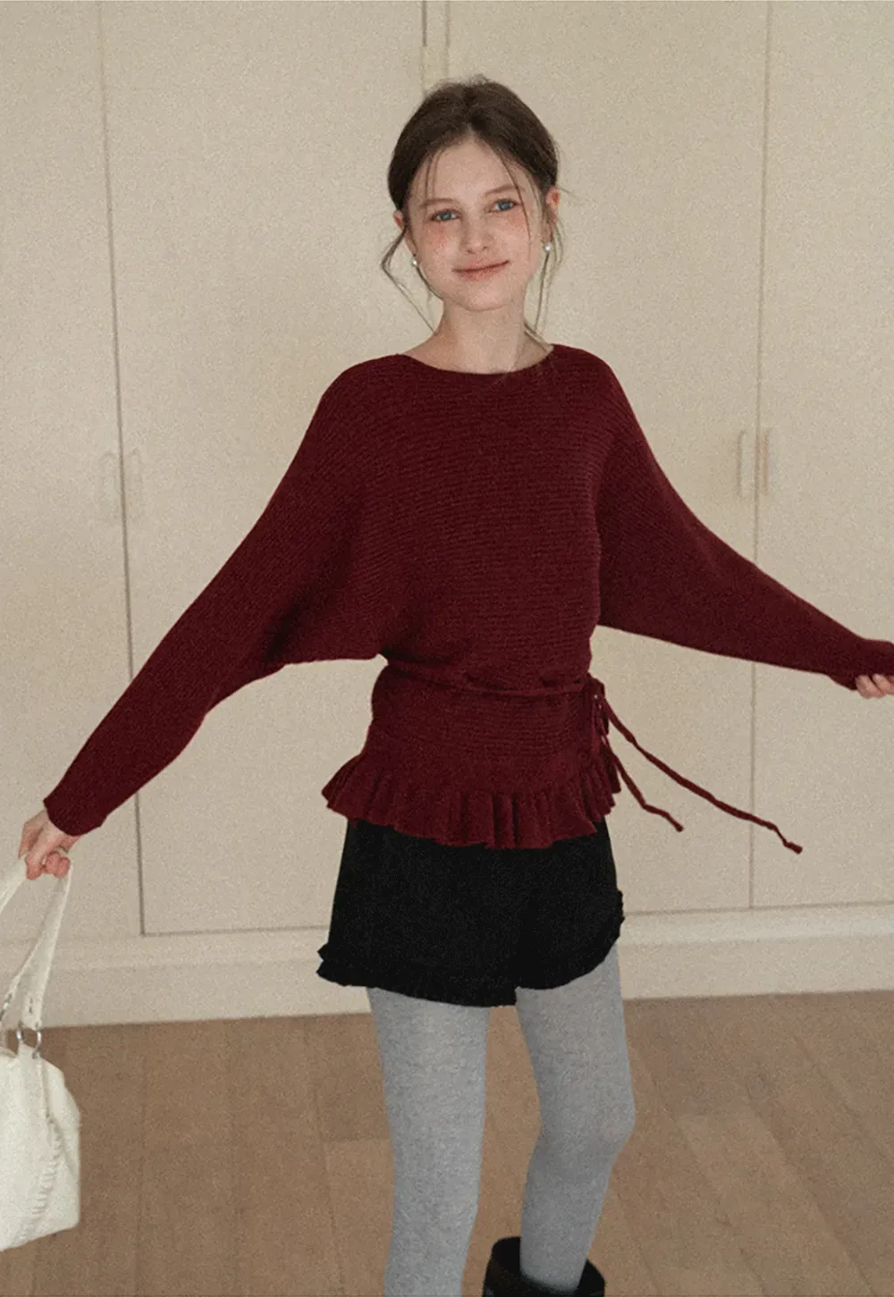 Ribbed knit sweater with tie back and flared hem design