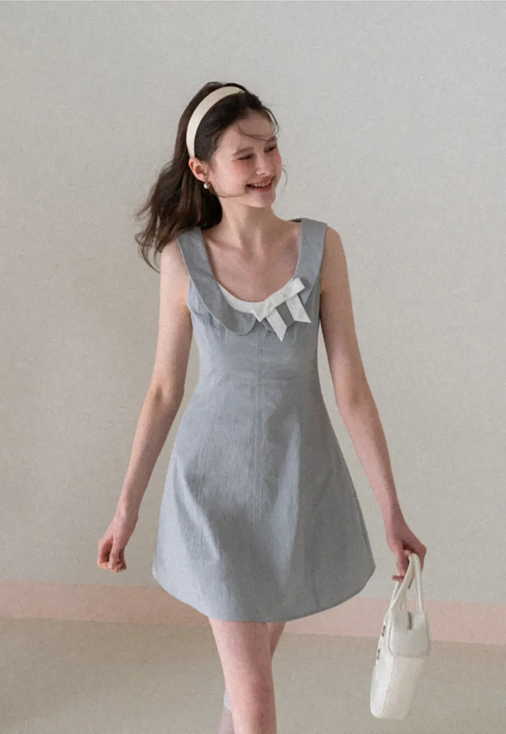 Sleeveless dress with Peter Pan collar and bow detail