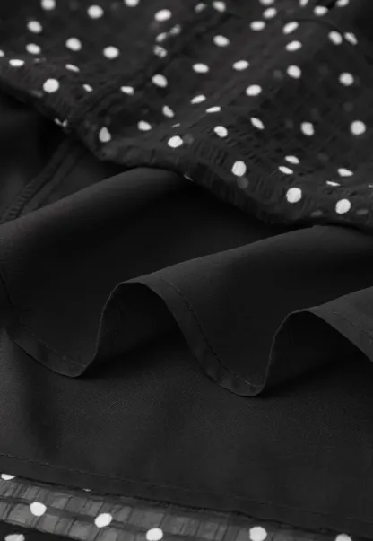 Sheer polka dot blouse with ruffled neckline and long sleeves