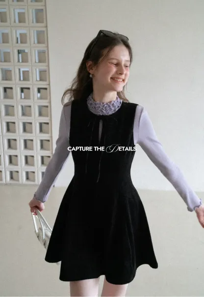 Elegant sleeveless dress with ruffled collar and bow tie design