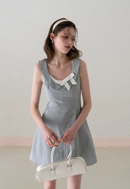 Sleeveless dress with Peter Pan collar and bow detail