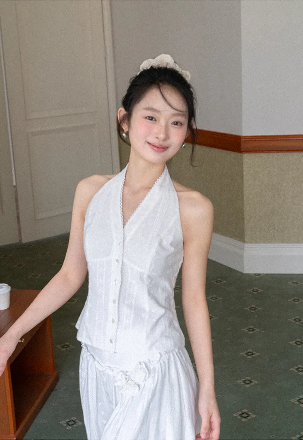 Halter neck sleeveless top with buttons and pleated skirt