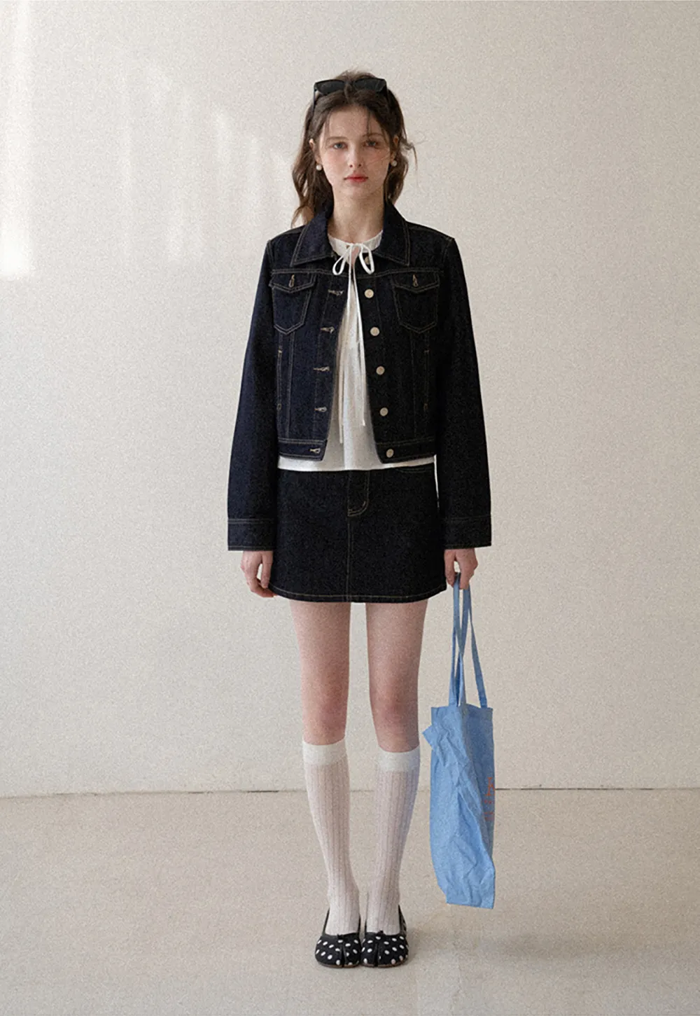 A-line denim skirt with front pocket design and adjustable waistband.