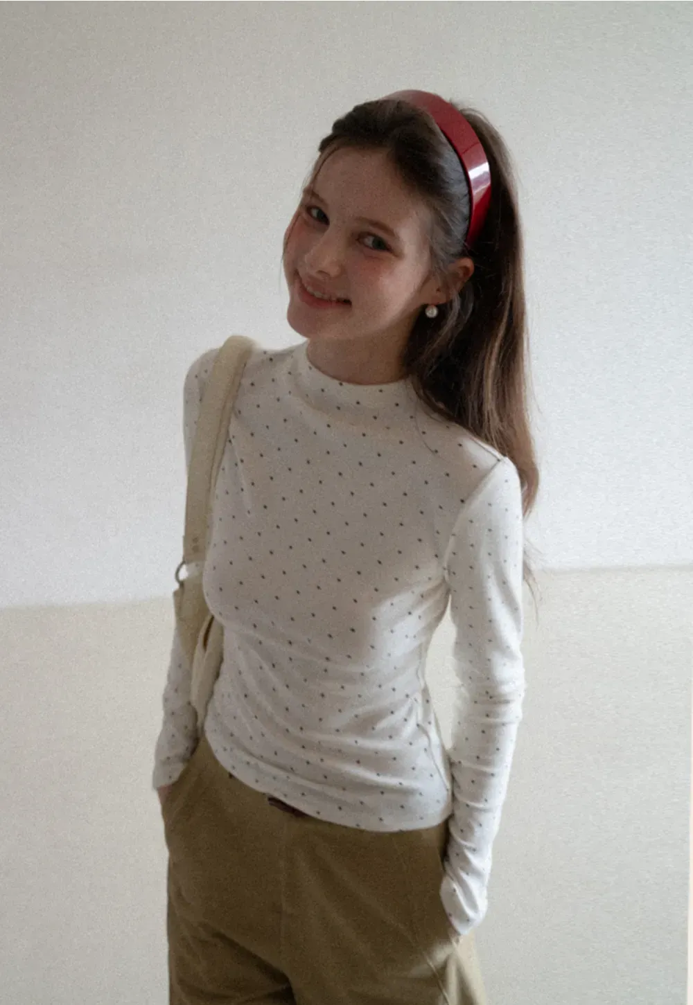 Elegant sleeveless dress with collar layered over polka dot top