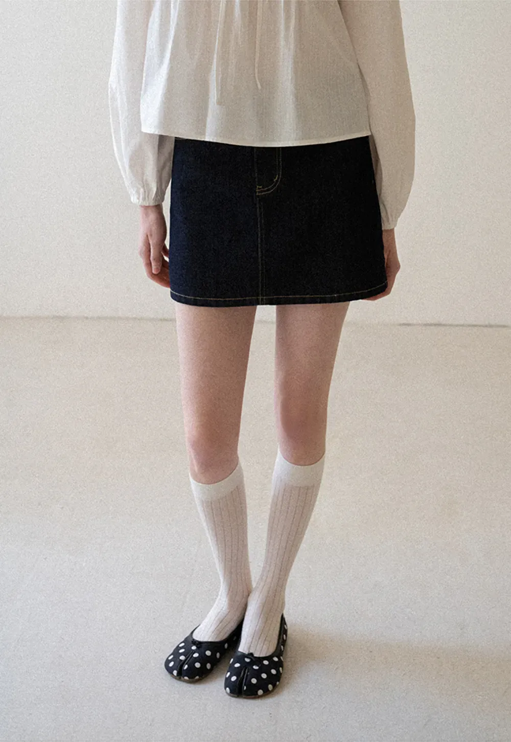 A-line denim skirt with front pocket design and adjustable waistband.