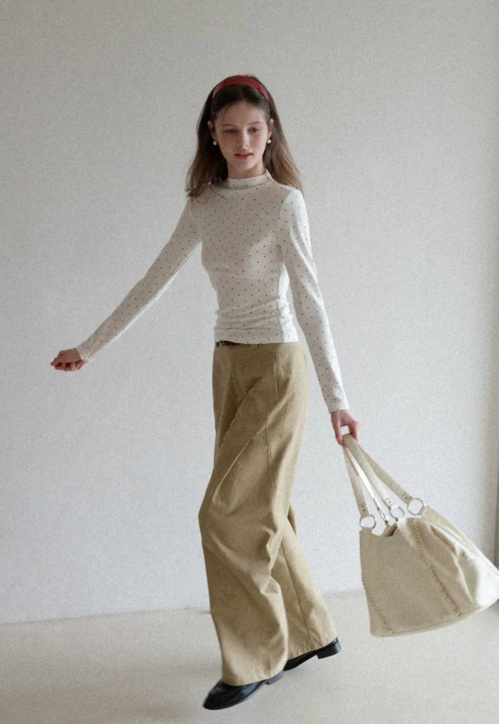 Elegant sleeveless dress with collar layered over polka dot top