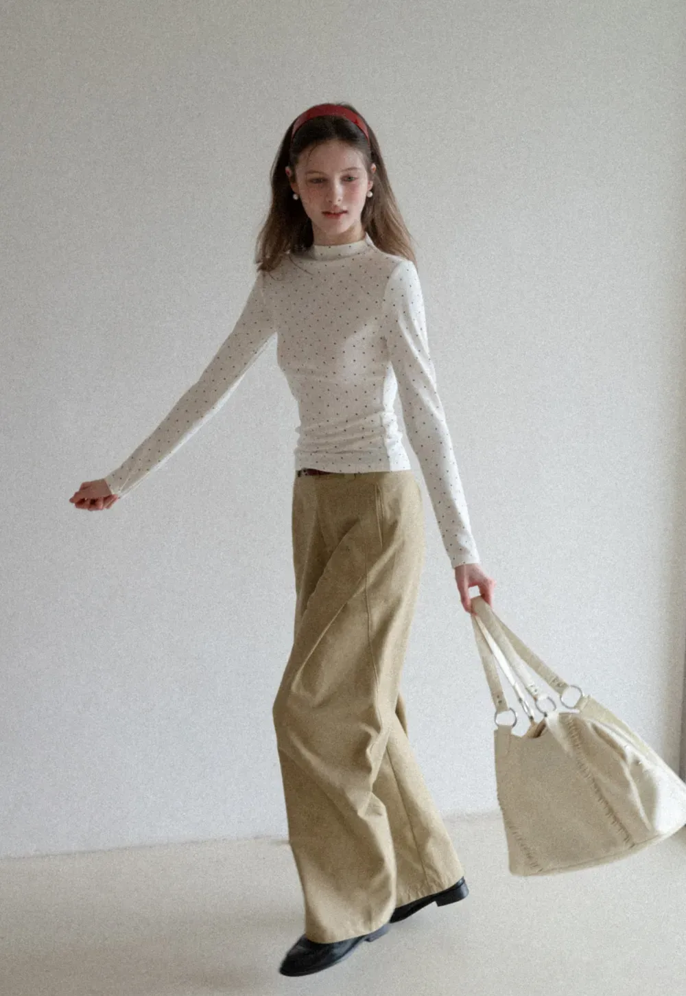 Elegant sleeveless dress with collar layered over polka dot top