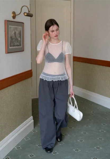 Sheer polka dot top with ruffled hem and puff sleeves