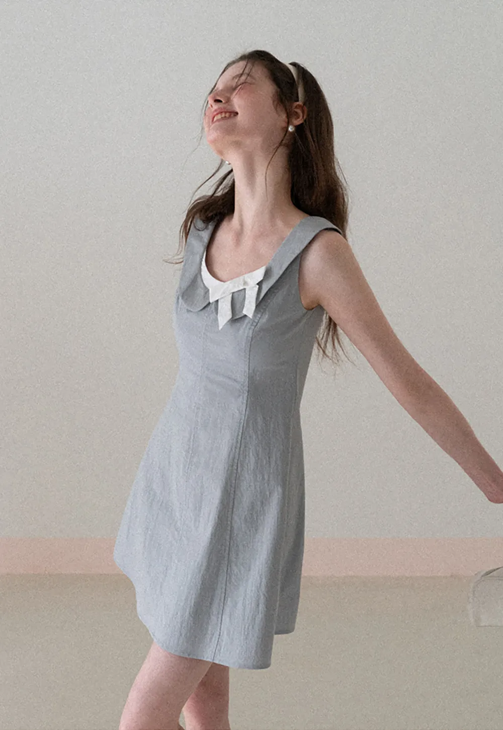 Sleeveless dress with Peter Pan collar and bow detail