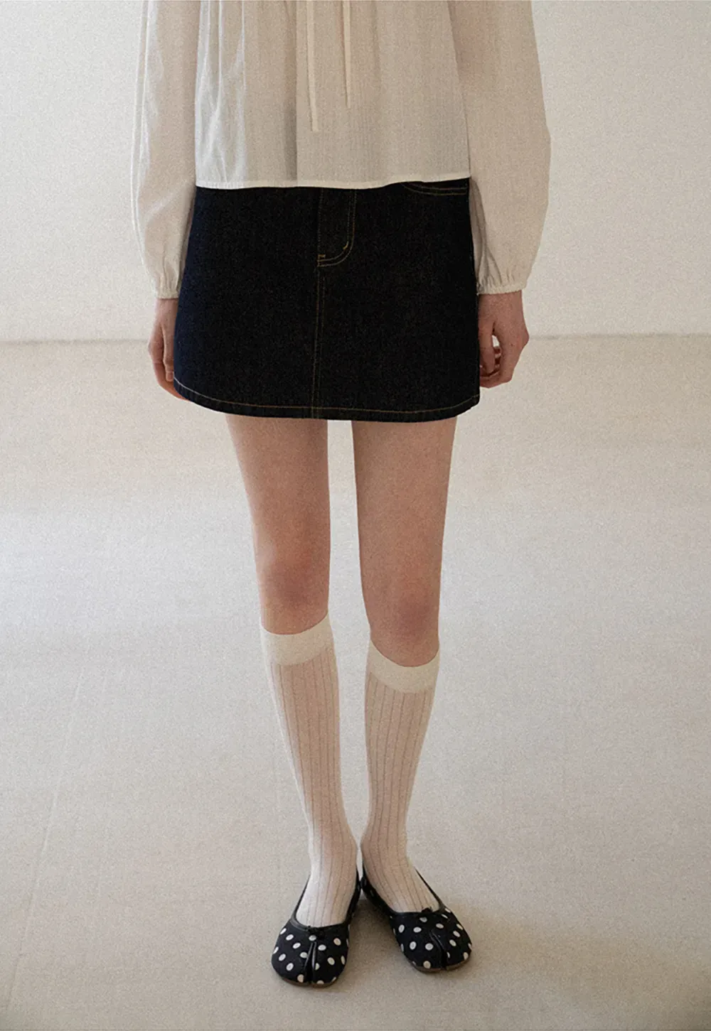 A-line denim skirt with front pocket design and adjustable waistband.