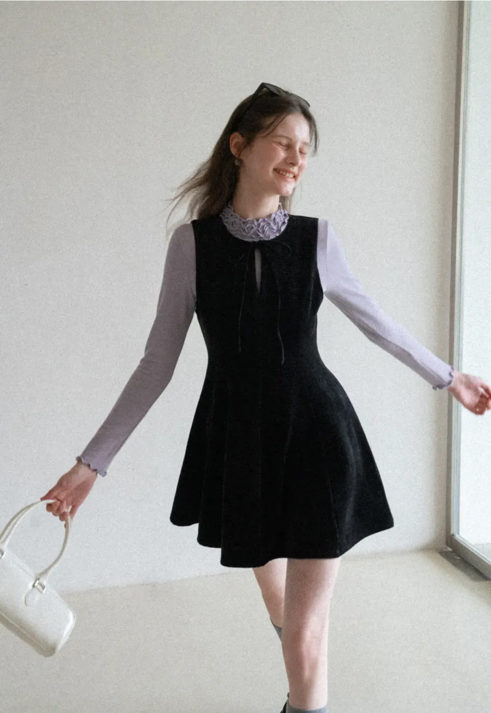 Elegant sleeveless dress with ruffled collar and bow tie design