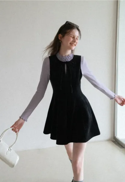 Elegant sleeveless dress with ruffled collar and bow tie design