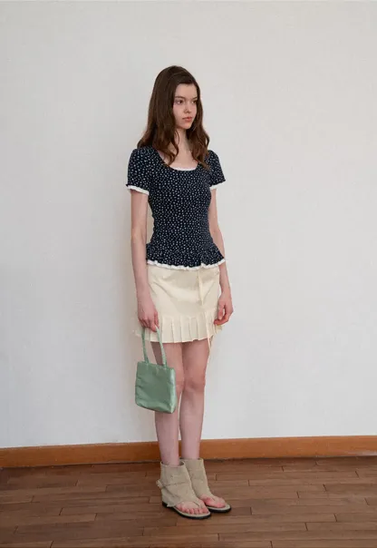 Short sleeve top with polka dot pattern and ruffled hem