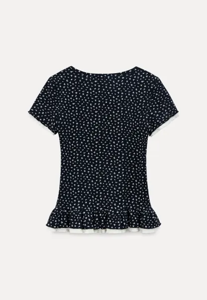 Short sleeve top with polka dot pattern and ruffled hem
