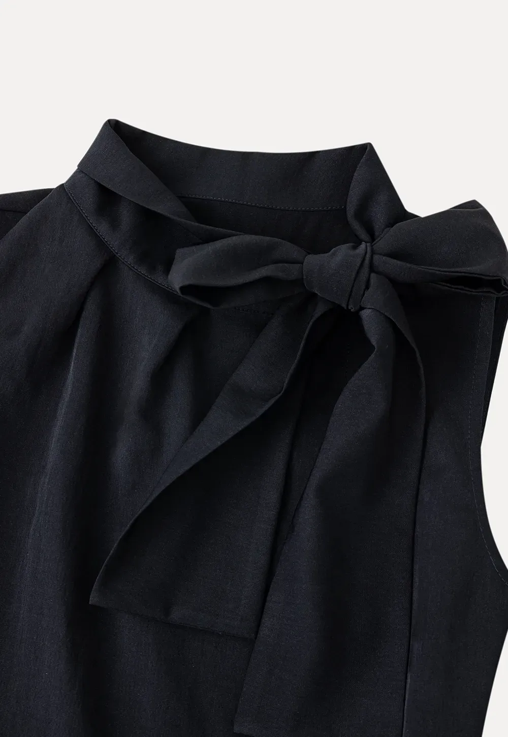 Sleeveless top with bow detail and pleated skirt