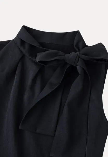 Sleeveless top with bow detail and pleated skirt