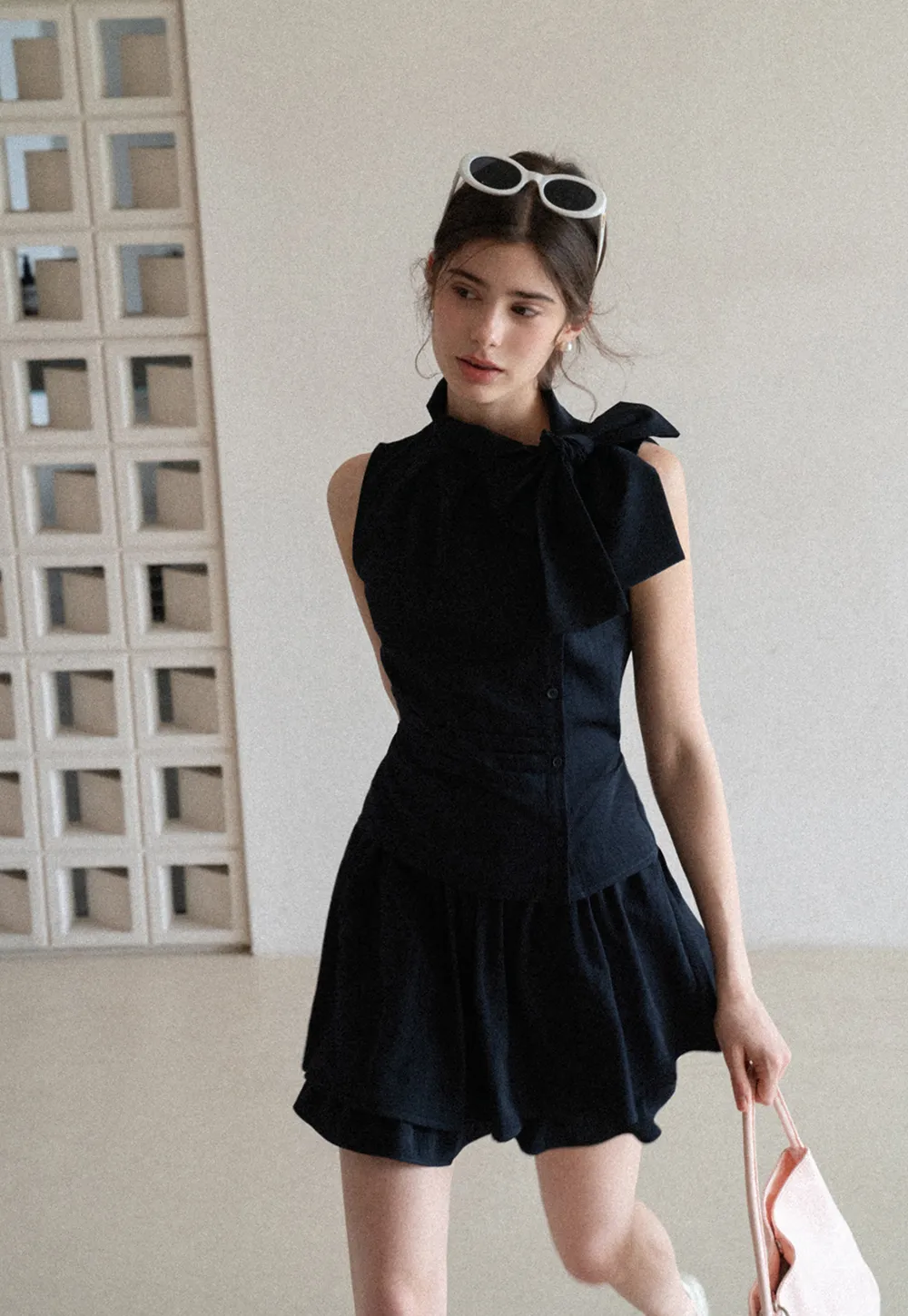 Sleeveless top with bow detail and pleated skirt