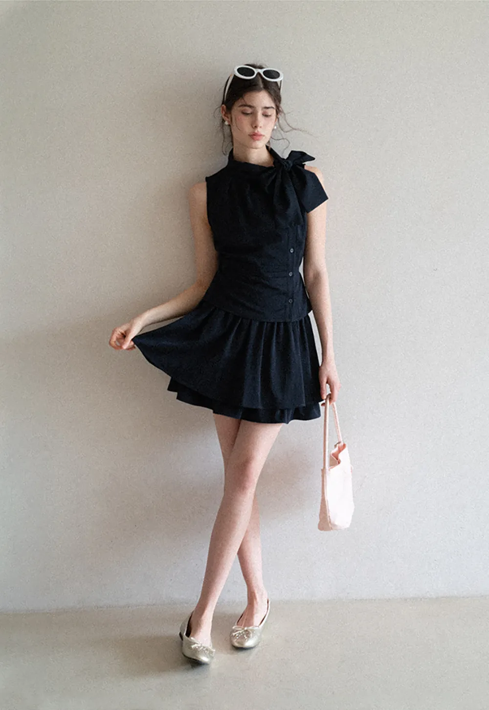 Sleeveless top with bow detail and pleated skirt