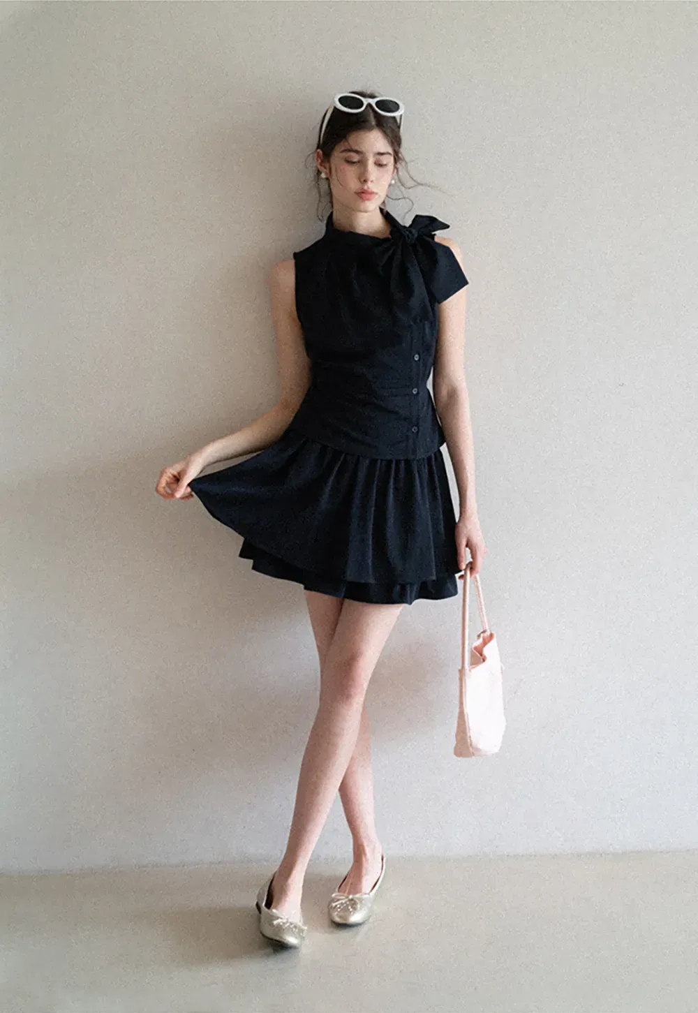 Sleeveless top with bow detail and pleated skirt