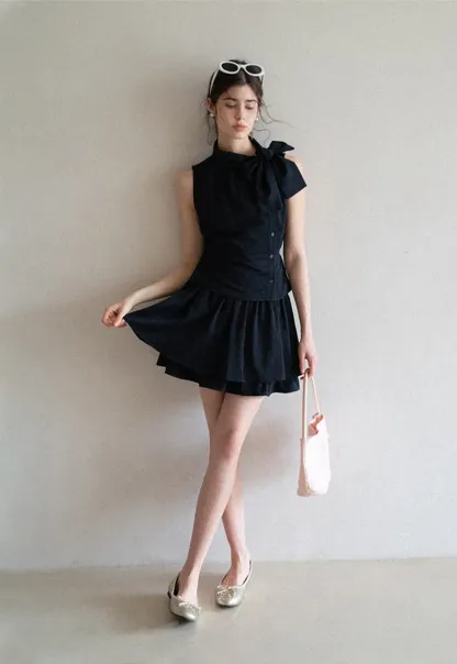 Sleeveless top with bow detail and pleated skirt