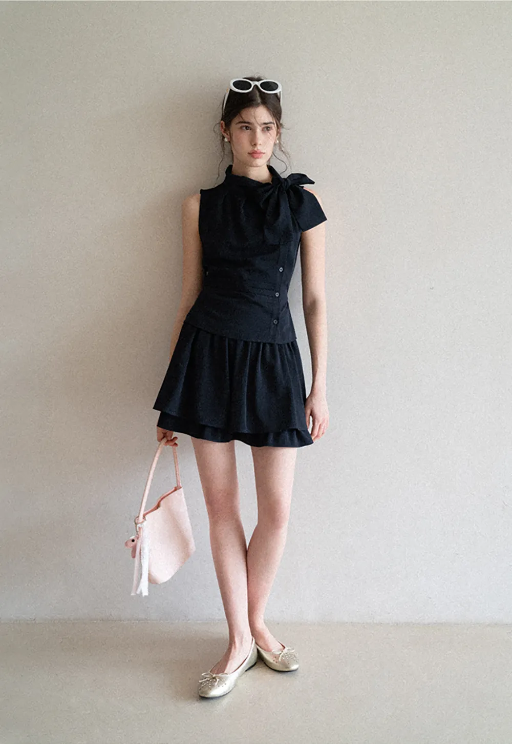 Sleeveless top with bow detail and pleated skirt