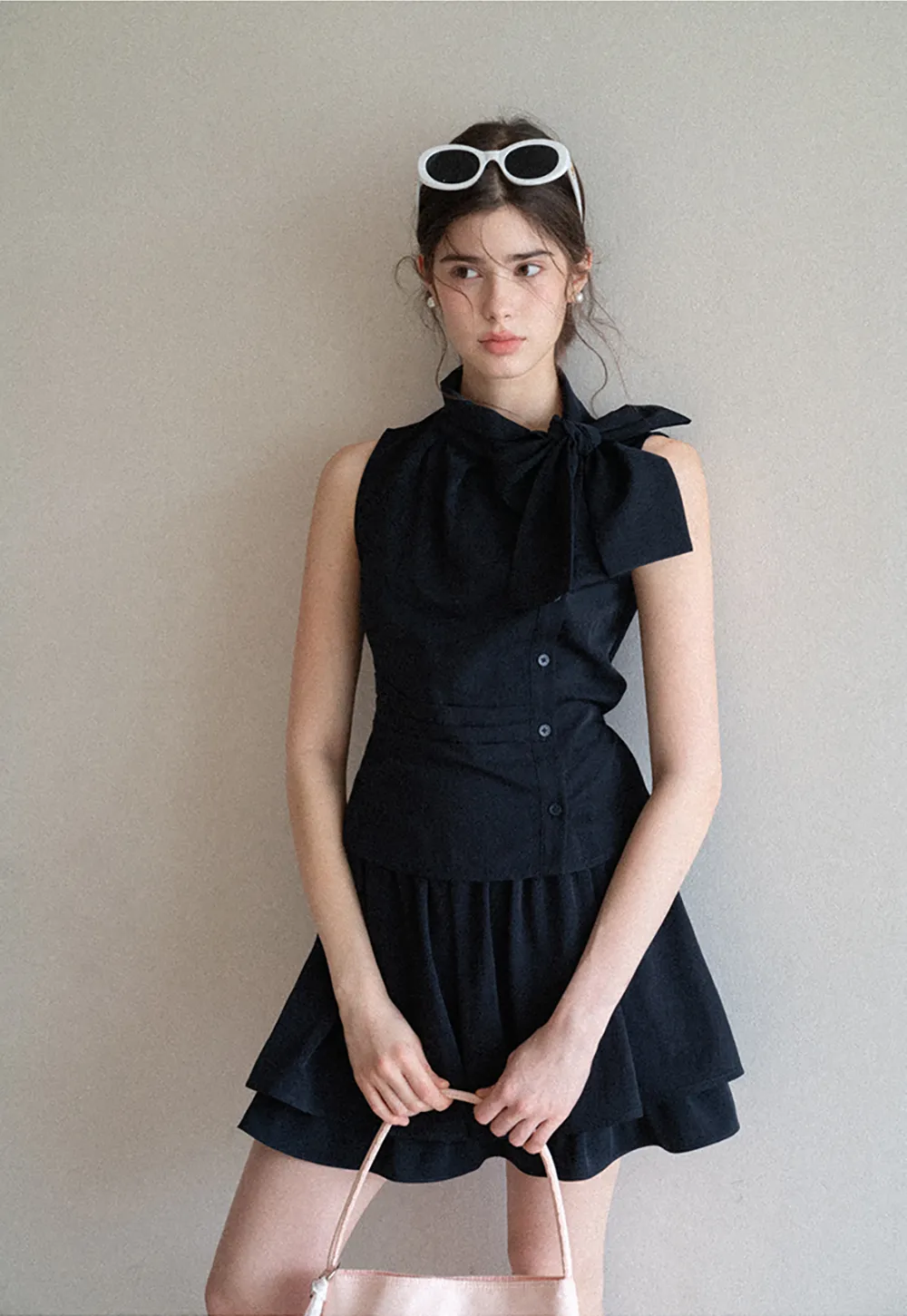 Sleeveless top with bow detail and pleated skirt