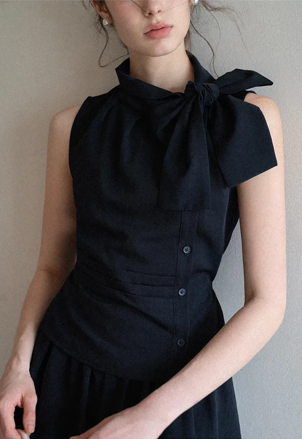 Sleeveless top with bow detail and pleated skirt