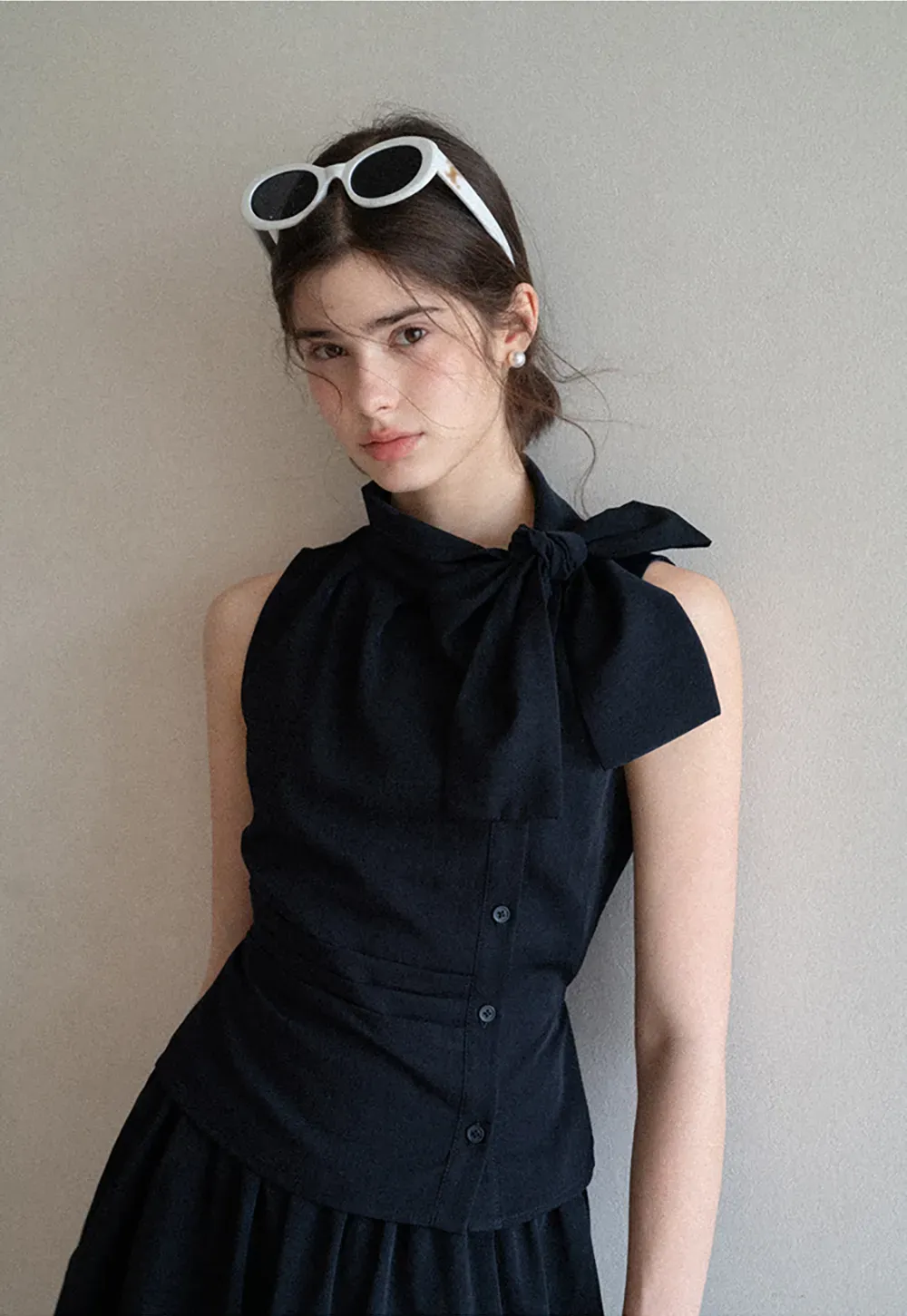 Sleeveless top with bow detail and pleated skirt