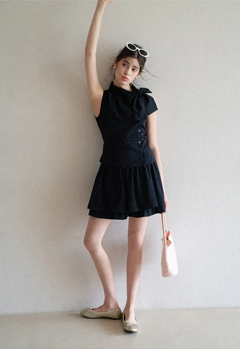 Sleeveless top with bow detail and pleated skirt