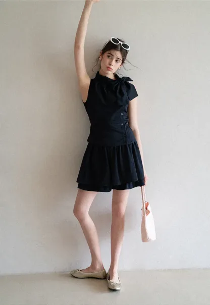 Sleeveless top with bow detail and pleated skirt