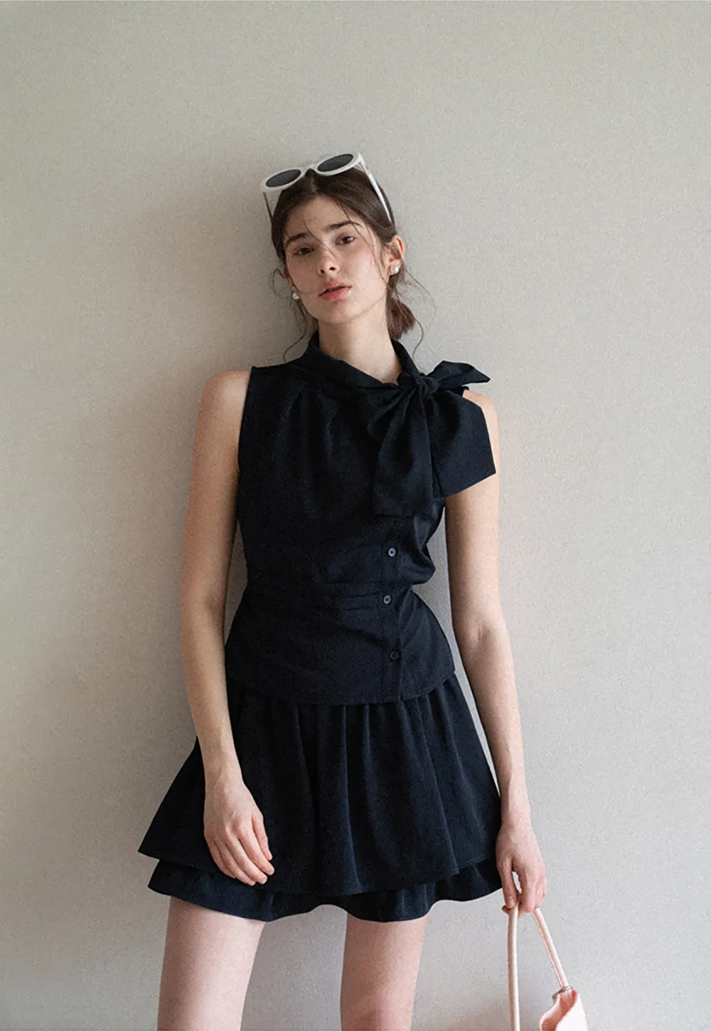 Sleeveless top with bow detail and pleated skirt
