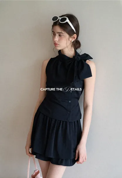 Sleeveless top with bow detail and pleated skirt