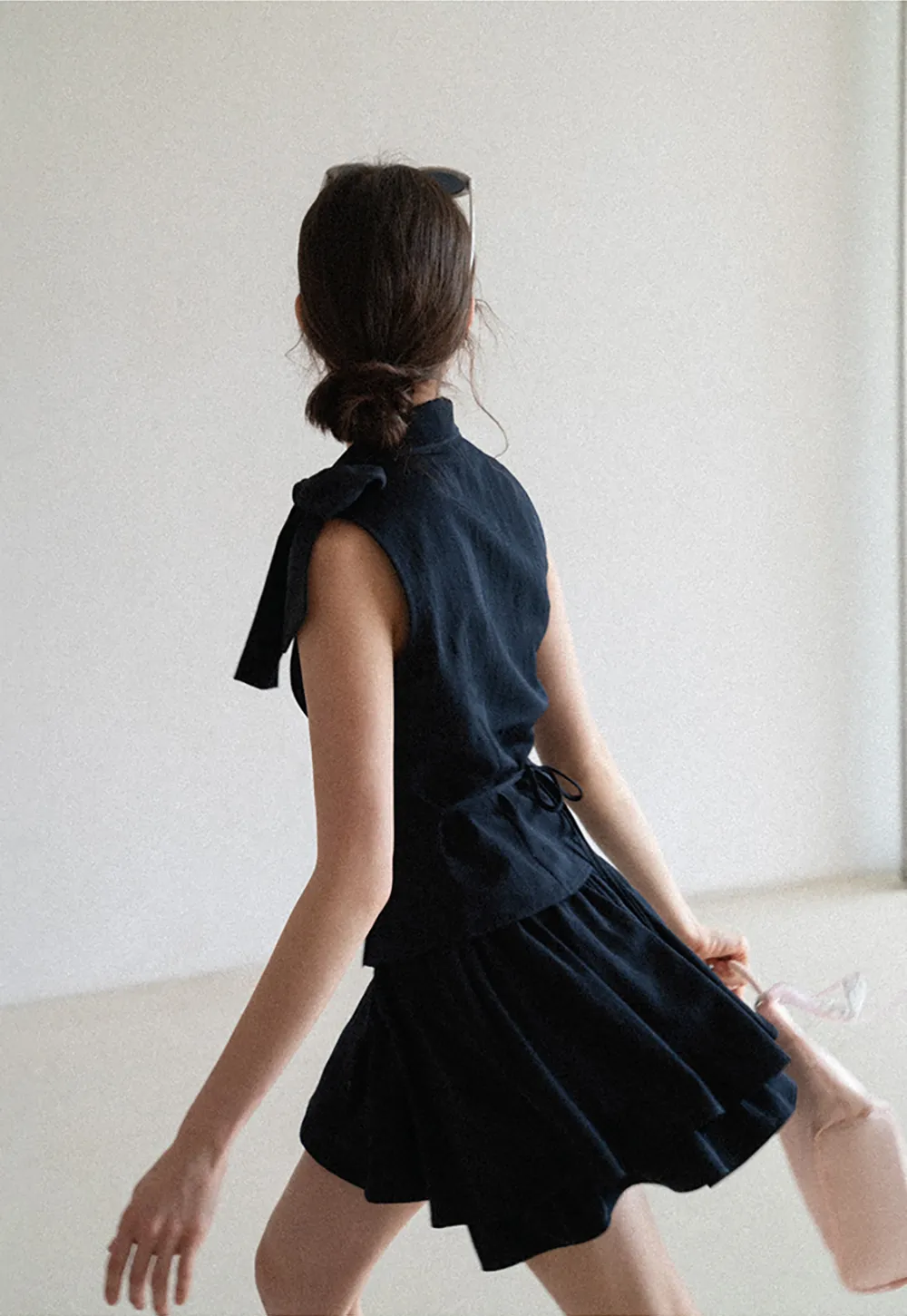Sleeveless top with bow detail and pleated skirt