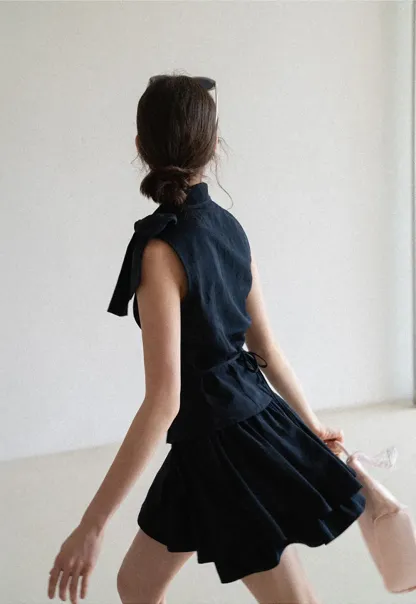 Sleeveless top with bow detail and pleated skirt