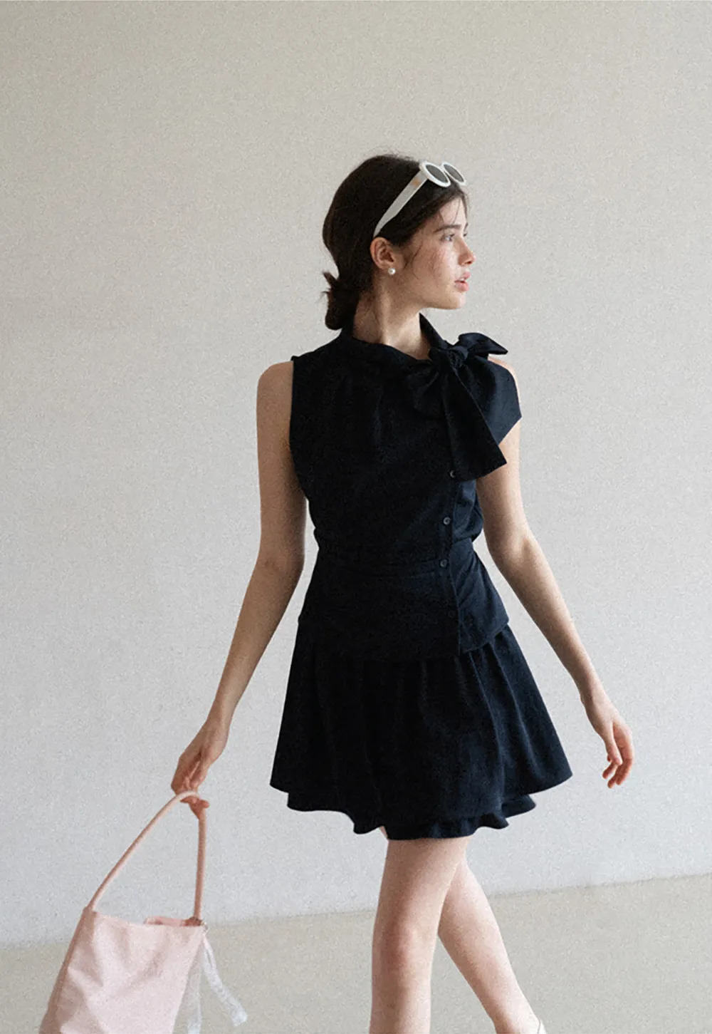 Sleeveless top with bow detail and pleated skirt