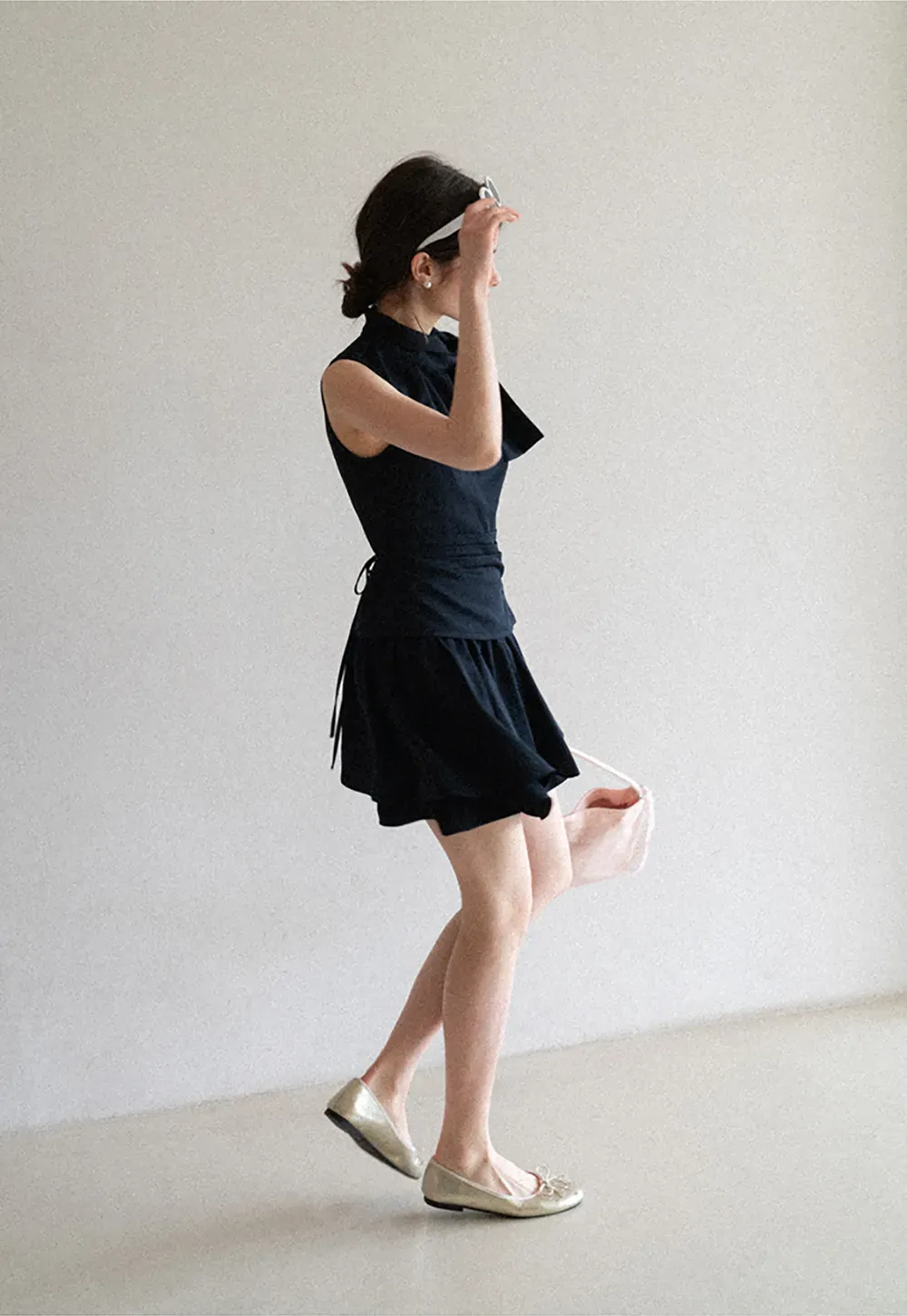 Sleeveless top with bow detail and pleated skirt