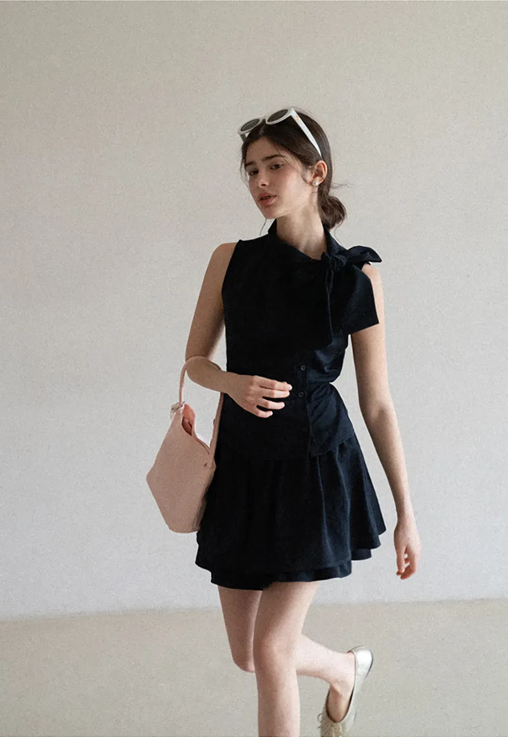 Sleeveless top with bow detail and pleated skirt