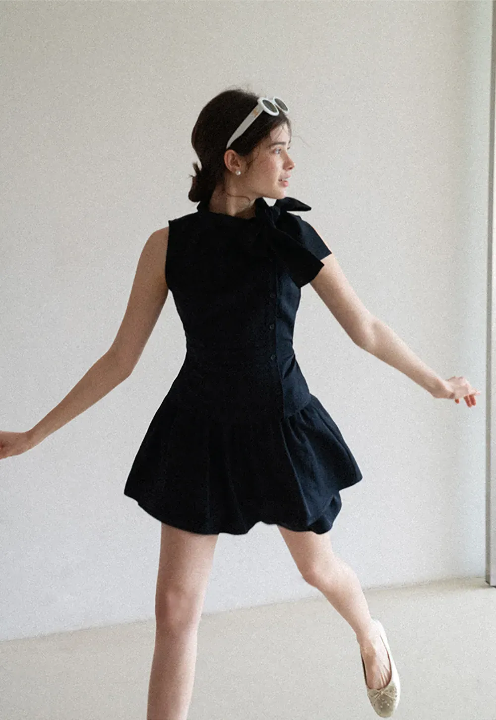 Sleeveless top with bow detail and pleated skirt