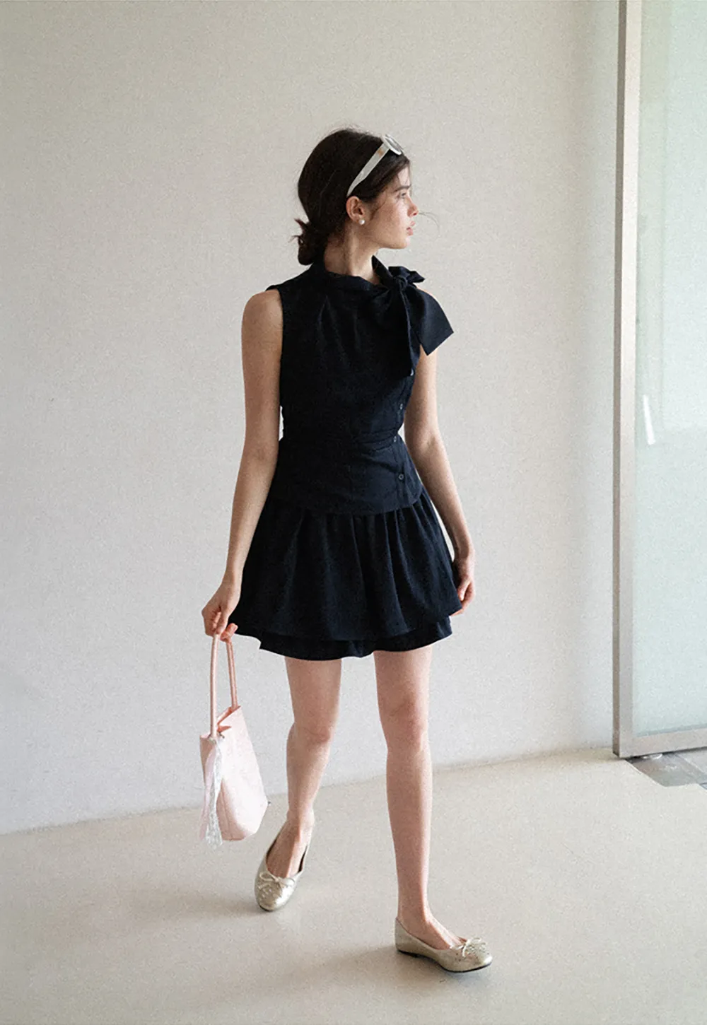Sleeveless top with bow detail and pleated skirt