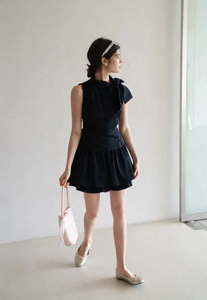 Sleeveless top with bow detail and pleated skirt
