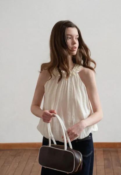 Sleeveless blouse with ruffled neckline and pleats