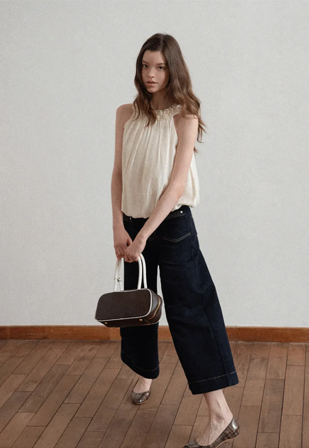 Sleeveless blouse with ruffled neckline and pleats