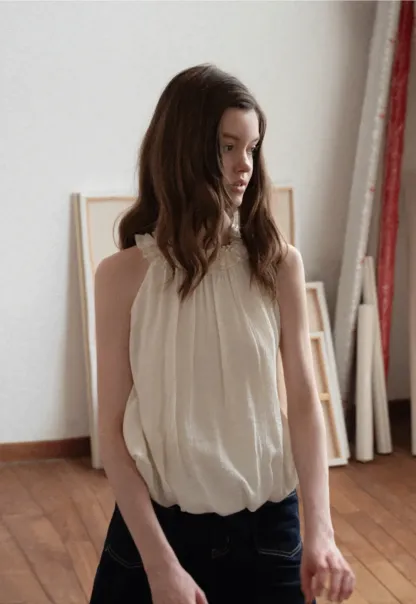 Sleeveless blouse with ruffled neckline and pleats