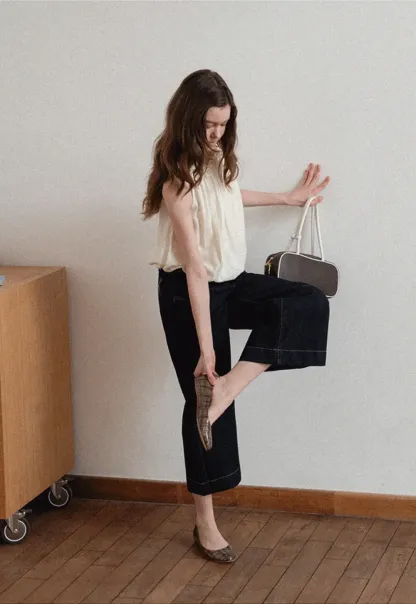 Sleeveless blouse with ruffled neckline and pleats